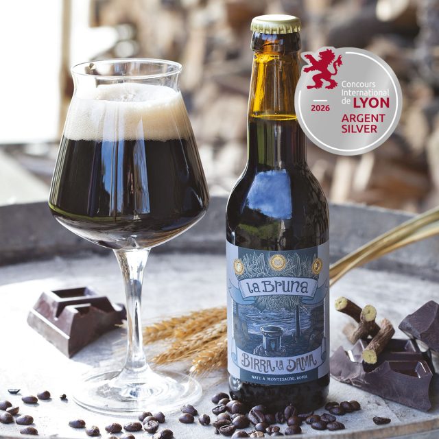 Birra La Bruna di Birra La Dama nel calice con chicchi di caffè, cioccolato e medaglia d'argento Lyon 2026.