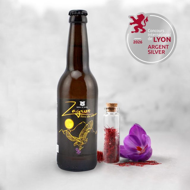Birra Zagros allo zafferano di Birra La Dama con fiori, pistilli e medaglia d'argento Lyon 2026 su sfondo neutro.
